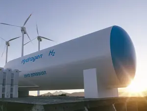 Wasserstofftank mit Windrädern im Hintergrund bei Sonnenuntergang, Beschriftung „zero emission“.
